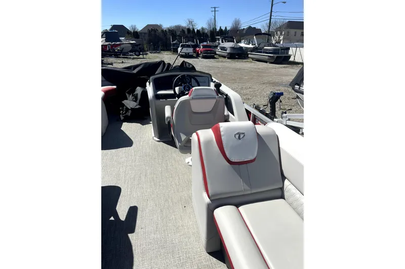 Slide: The Image of 2023 Tahoe Pontoon 2385 Cascade Quad Lounger interior with plush seating and steering console. - 7