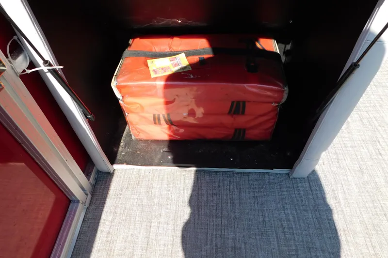 Slide: The Image of Storage compartment with orange life jackets on a 2023 Tahoe Pontoon 2385 LTZ Quad Lounger. - 51