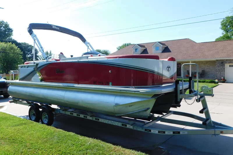 The Image of 2023 Tahoe Pontoon 2385 LTZ Quad Lounger on trailer, parked in driveway. - 0