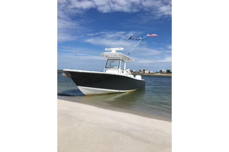 The Image of 2020 Sportsman Open 282 Center Console boat on sandy beach under blue sky. - 0