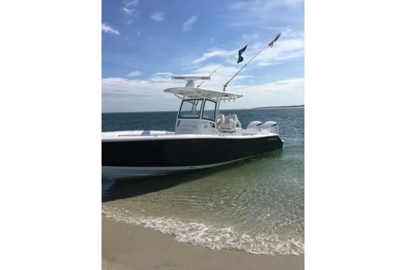 Slide: The Image of 2020 Sportsman Open 282 Center Console boat on sandy beach with clear blue sky. - 5