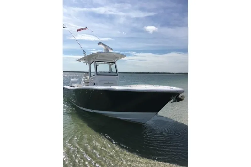 Slide: The Image of 2020 Sportsman Open 282 Center Console boat on calm water under blue sky. - 6