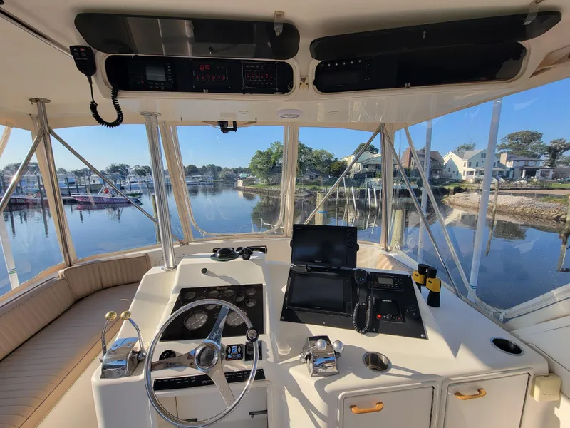 Slide: The Image of Cockpit view of a 1991 Ocean Yachts 42 Super Sport, docked in a serene marina. - 20