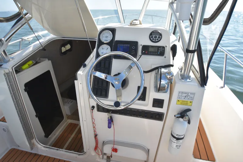 Slide: The Image of Helm of a 2007 Shamrock 246 Adventurer boat on the water. - 23