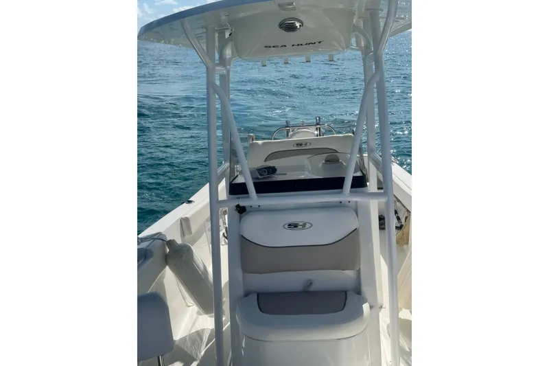 Slide: The Image of 2013 Sea Hunt Ultra 234 boat on open water, featuring a sleek design and spacious deck. - 4