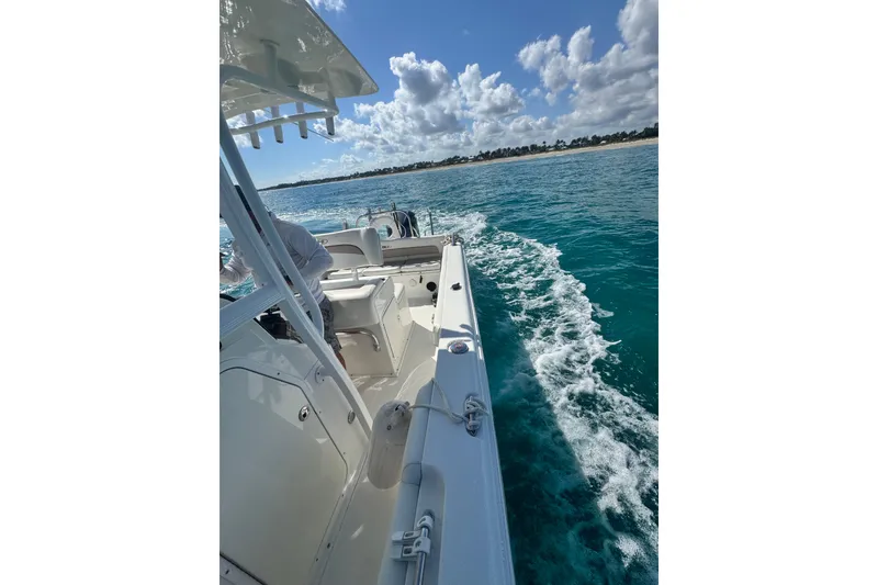 Slide: The Image of 2013 Sea Hunt Ultra 234 cruising on clear blue waters under a partly cloudy sky. - 6