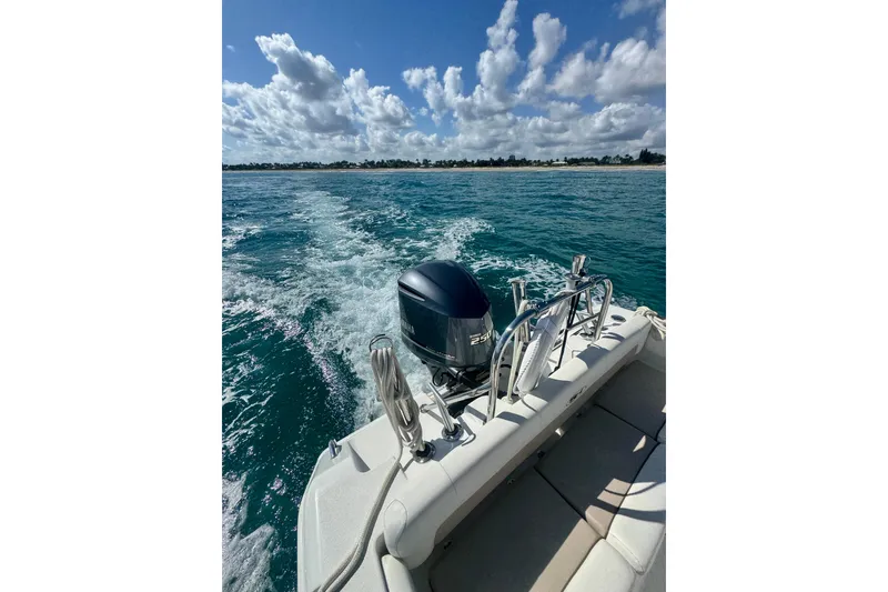 Slide: The Image of 2013 Sea Hunt Ultra 234 boat cruising on clear blue ocean under a partly cloudy sky. - 7