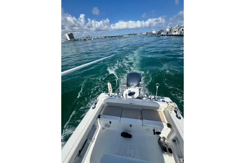 Slide: The Image of 2013 Sea Hunt Ultra 234 boat cruising on clear blue water under a sunny sky. - 8