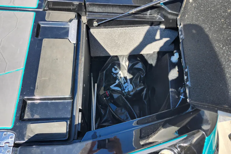 Slide: The Image of Open storage compartment in 2022 Malibu M220 boat, showing interior details and equipment. - 15