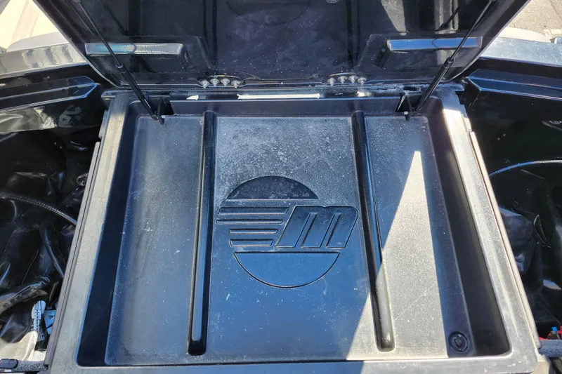 Slide: The Image of 2022 Malibu M220 storage compartment with logo, open lid, and hydraulic supports. - 18