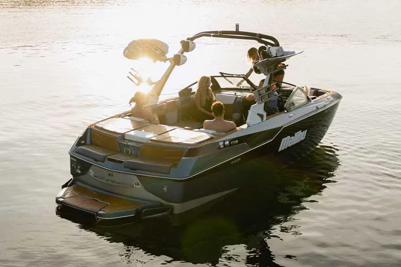 Slide: The Image of 2022 Malibu M220 boat at AM PM Marine dealership, covered and on trailer. - 2