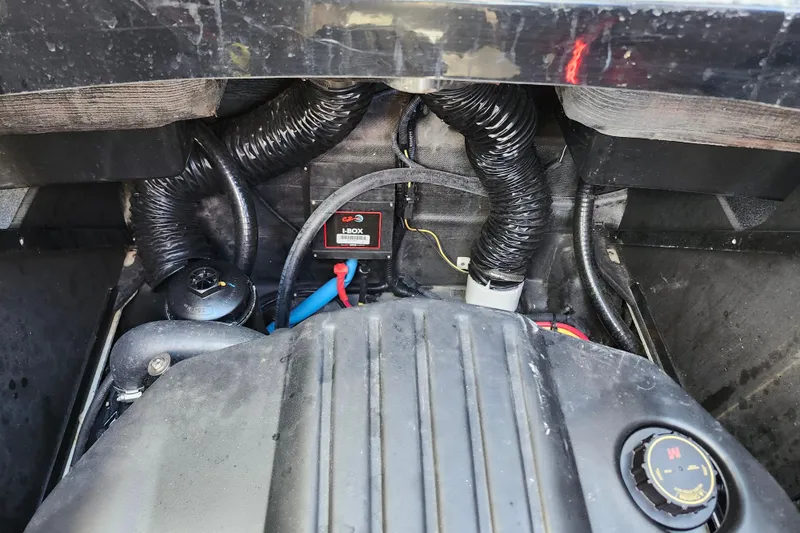 Slide: The Image of Engine compartment of 2022 Malibu M220 boat, showing hoses and components. - 20