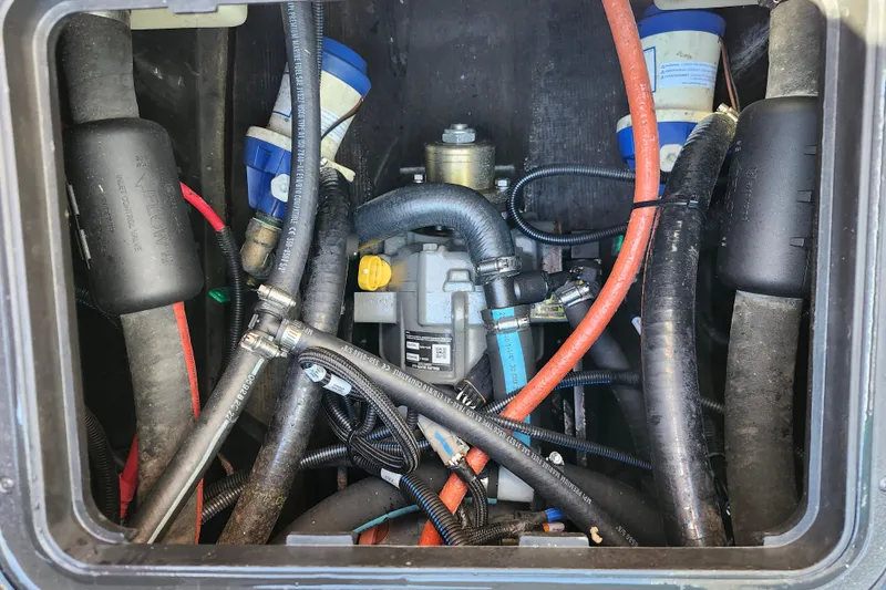 Slide: The Image of Engine compartment of a 2022 Malibu M220 boat with visible hoses and components. - 21