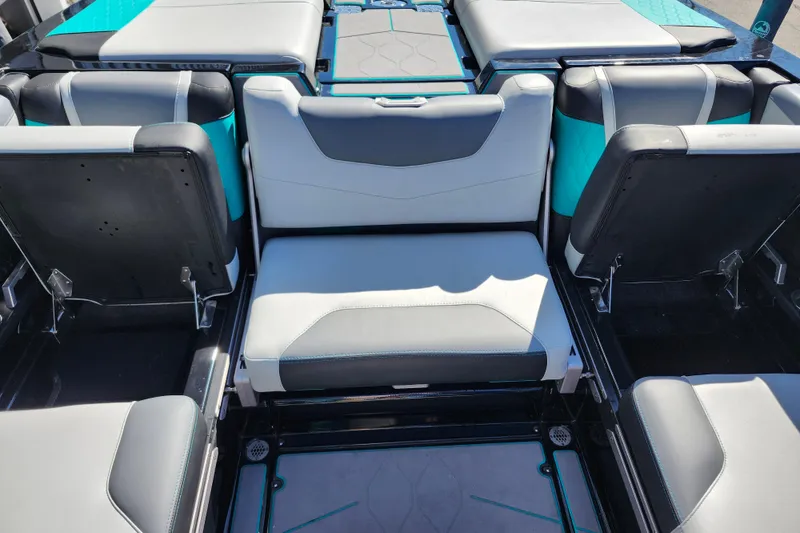 Slide: The Image of 2022 Malibu M220 boat interior with gray and teal seating arrangement. - 26