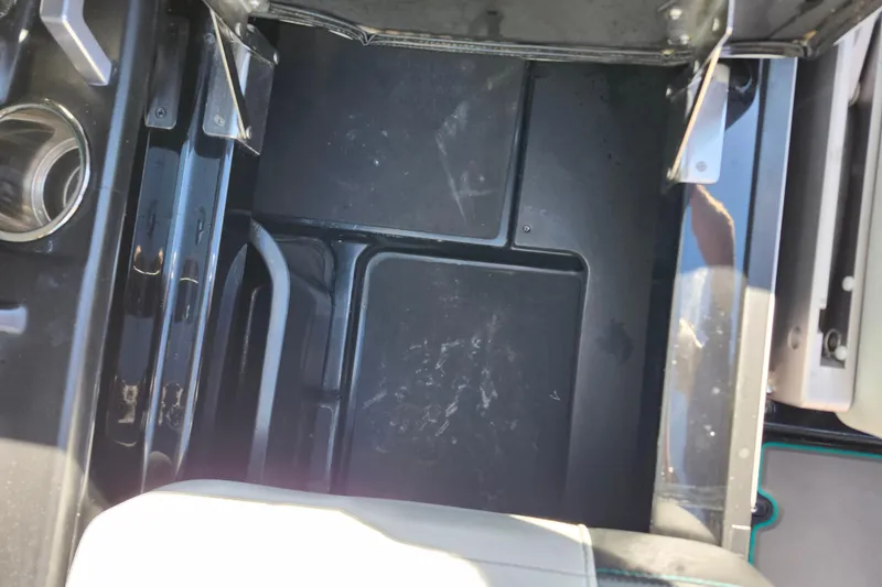 Slide: The Image of 2022 Malibu M220 boat storage compartment with cup holder and seating area. - 27