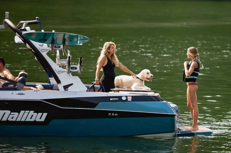 Slide: The Image of 2022 Malibu M220 boat at AM PM Marine dealership, vibrant blue exterior. - 3