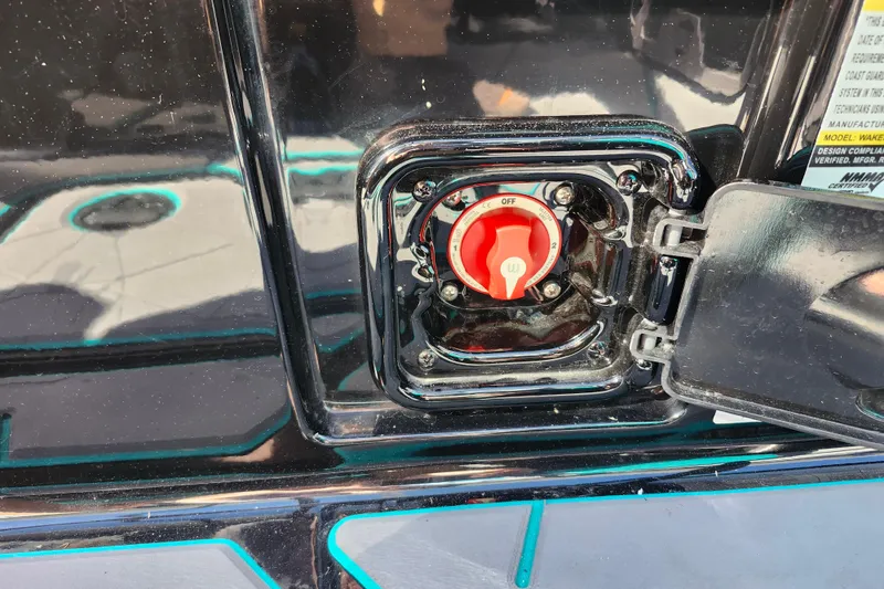 Slide: The Image of 2022 Malibu M220 boat battery switch with red handle and protective cover. - 31