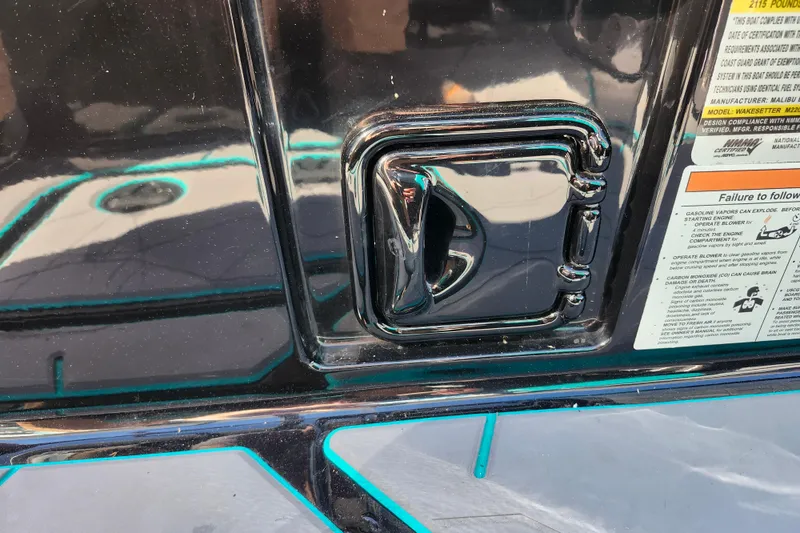 Slide: The Image of Close-up of 2022 Malibu M220 boat handle and safety instructions. - 32