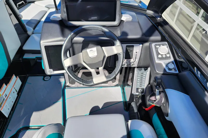 Slide: The Image of 2022 Malibu M220 boat cockpit with modern steering wheel and control panel. - 35