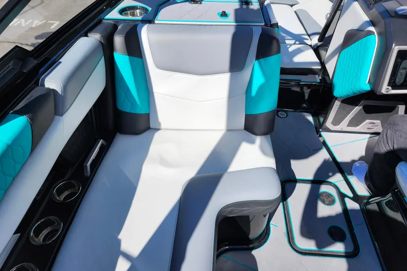 Slide: The Image of 2022 Malibu M220 boat interior with turquoise and gray seating, cup holders, and modern design. - 38