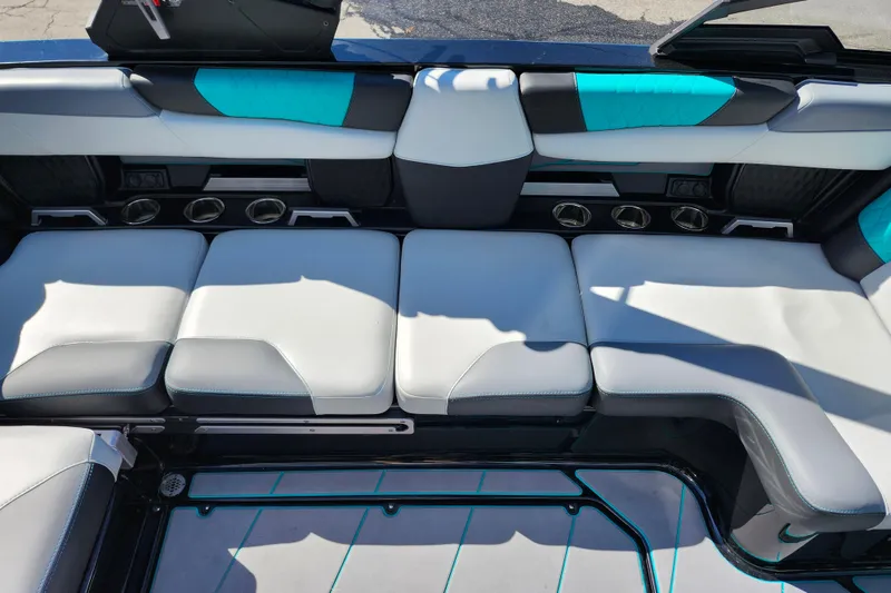 Slide: The Image of 2022 Malibu M220 boat interior with white and teal seating, cup holders, and modern design. - 39