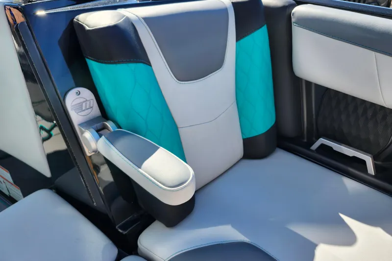 Slide: The Image of 2022 Malibu M220 boat interior with teal and gray seating, featuring armrest and stylish design. - 48