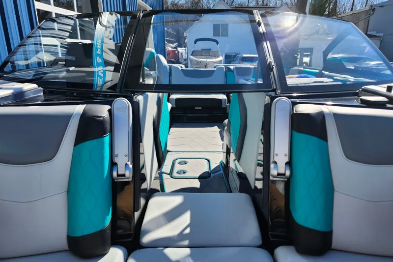 Slide: The Image of Interior view of 2022 Malibu M220 boat with teal and gray seating. - 50
