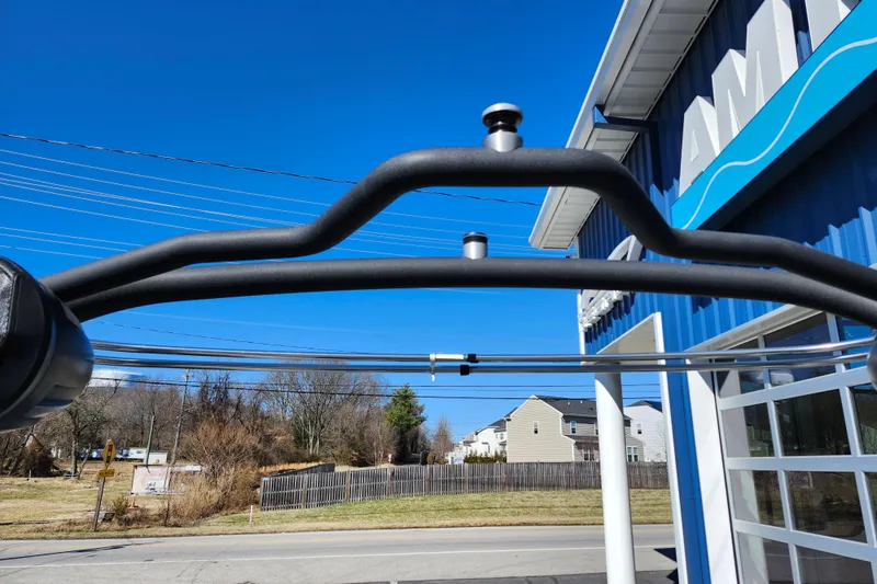 Slide: The Image of 2022 Malibu M220 boat tower against clear blue sky and building backdrop. - 55