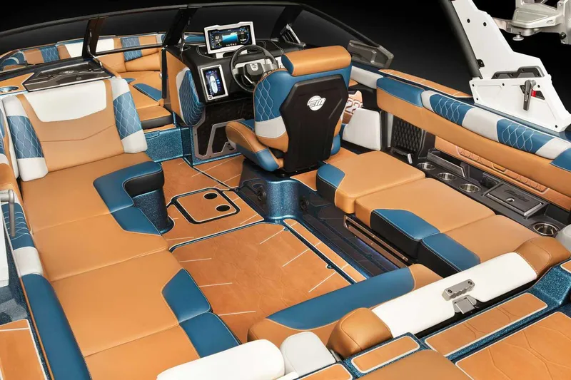 Slide: The Image of 2022 Malibu M220 boat in vibrant teal, parked outside a blue building. - 6