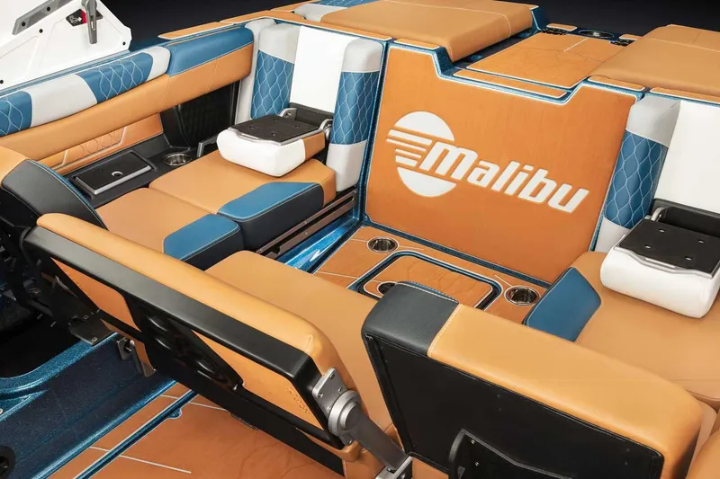 Slide: The Image of Manufacturer Provided Image: 2022 Malibu M220 boat interior with tan and blue seating, cup holders, and logo. - 71