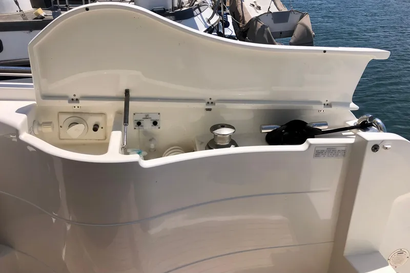 Slide: The Image of 2006 Ferretti Yachts 550 yacht deck with open storage compartment, docked by the water. - 24