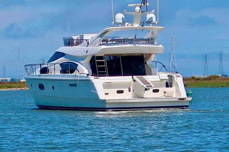 Slide: The Image of 2006 Ferretti Yachts 550 cruising on a serene waterway under a clear blue sky. - 5