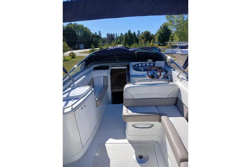 Slide: The Image of 1998 Cobalt 293 boat interior with seating and control panel, parked outdoors. - 13