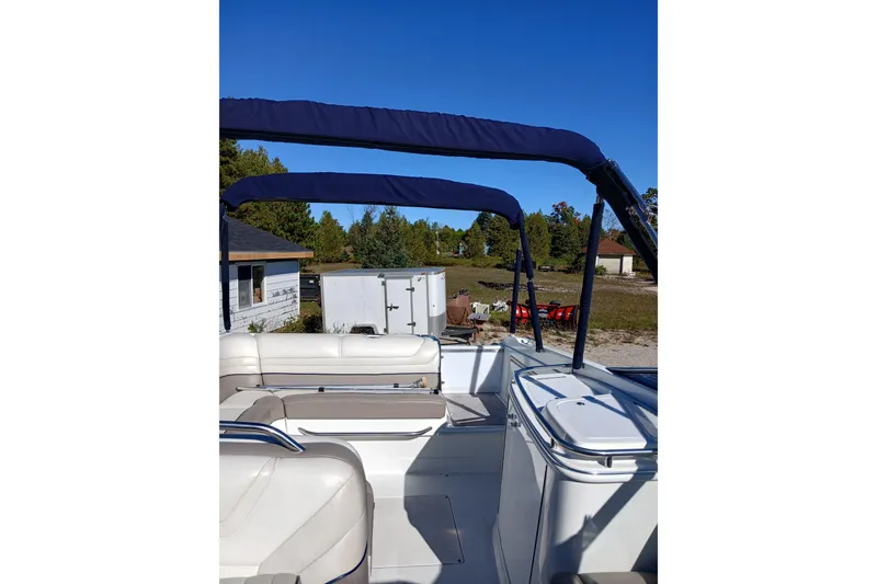 Slide: The Image of 1998 Cobalt 293 boat interior with blue canopy and white seating, outdoors. - 14