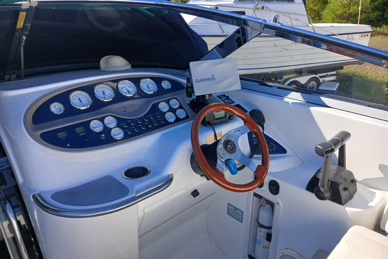 Slide: The Image of 1998 Cobalt 293 boat dashboard with Garmin navigation and wooden steering wheel. - 15