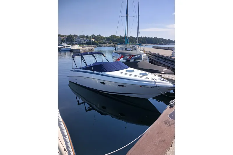 Slide: The Image of 1998 Cobalt 293 boat docked in a serene marina setting. - 2