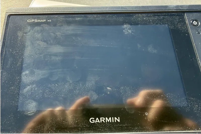 Slide: The Image of Garmin GPSMAP x5 device with fingerprints, reflecting sunlight, in a 1998 Cobalt 293 boat. - 24