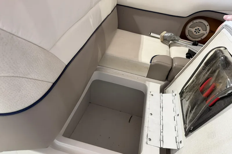 Slide: The Image of Open storage compartment in 1998 Cobalt 293 boat with beige seating and tools. - 26