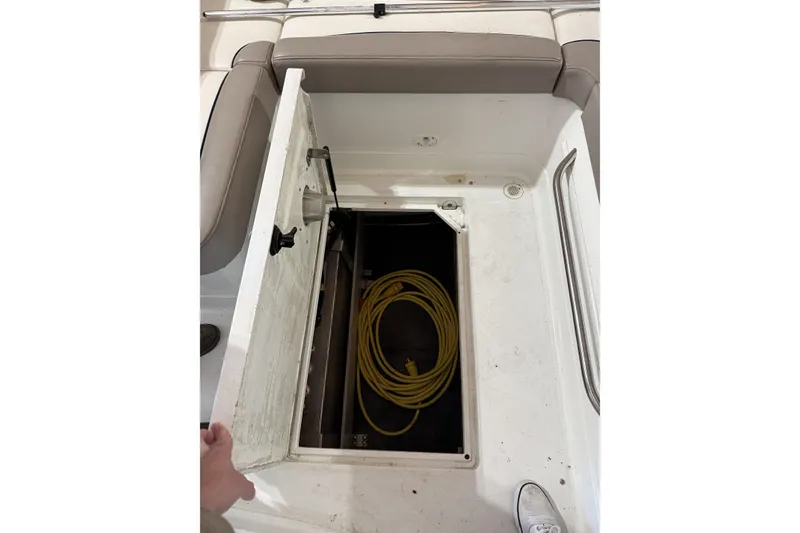 Slide: The Image of Open storage compartment on 1998 Cobalt 293 boat with yellow cable inside. - 27