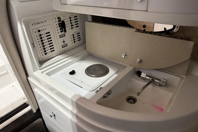 Slide: The Image of 1998 Cobalt 293 boat interior with control panel, stove, and sink. - 29