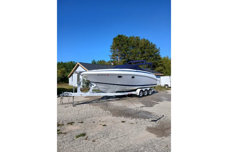 Slide: The Image of 1998 Cobalt 293 boat on trailer, parked outdoors under clear blue sky. - 4