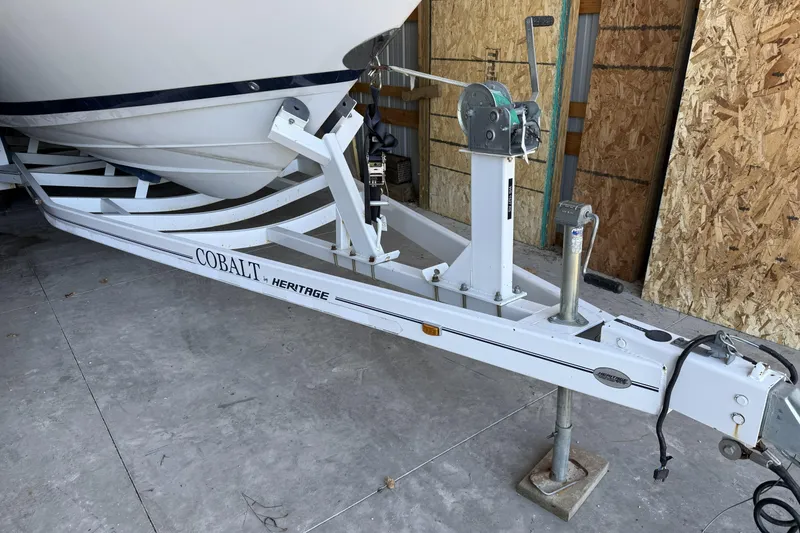 Slide: The Image of 1998 Cobalt 293 boat trailer, white, parked in a garage with wooden walls. - 6