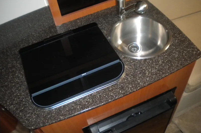 Slide: The Image of 2009 Maxum 2700 SE boat interior with compact sink and stove on countertop. - 14