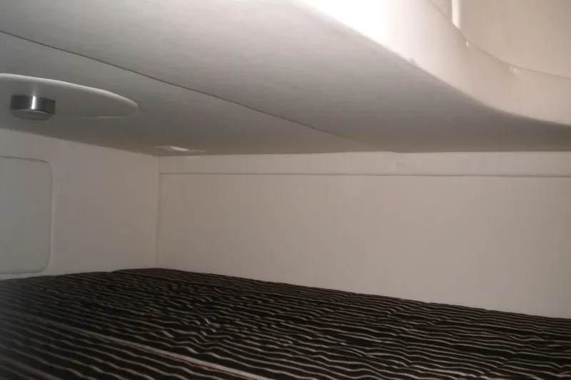 Slide: The Image of Interior cabin of 2009 Maxum 2700 SE boat with striped bedding. - 17