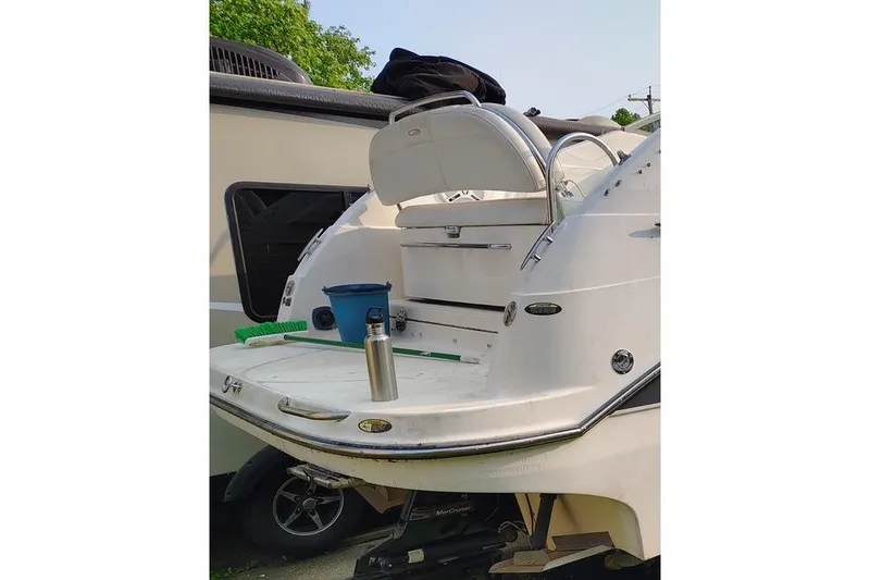 Slide: The Image of 2009 Maxum 2700 SE boat with swim platform, cleaning supplies, and outdoor setting. - 6
