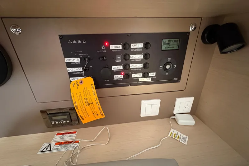 Slide: The Image of Control panel of a 2021 Beneteau Oceanis 38.1 sailboat with caution tags. - 11