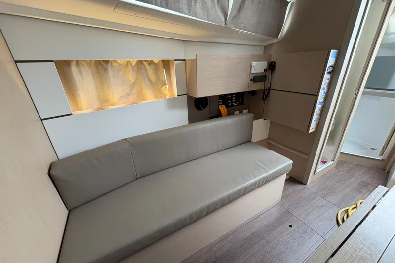 Slide: The Image of Interior of 2021 Beneteau Oceanis 38.1 yacht, featuring a sleek, modern seating area. - 12