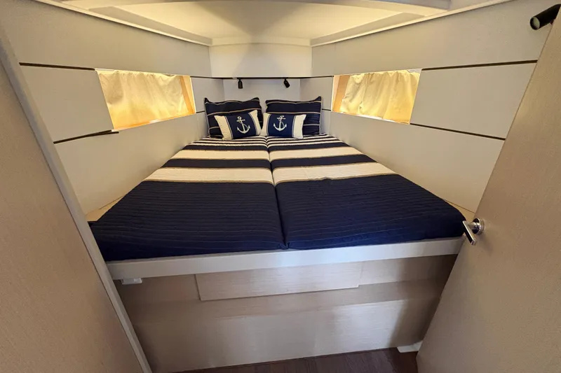 Slide: The Image of Cozy cabin interior of 2021 Beneteau Oceanis 38.1 with nautical-themed bedding. - 13