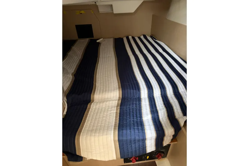 Slide: The Image of Beneteau Oceanis 38.1 2021 cabin with striped bedding, cozy and inviting interior. - 16