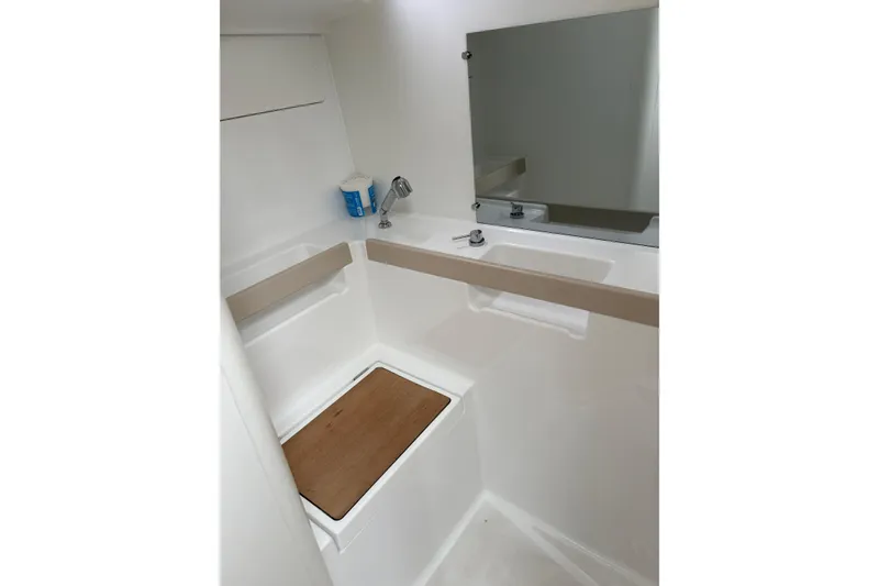 Slide: The Image of Beneteau Oceanis 38.1 2021 yacht bathroom with sink, mirror, and wooden seat. - 17